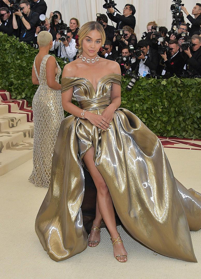 Моделът и актриса Жасмин Сандърс бе облечена с обемна рокля от златисто-бронзово метално ламе. Роклята е с лека драперия върху раменете и елегантна тънка талия. Драматичната обемна пола с дълга цепка разкриваше прелестните крака на Жасмин, акцентирайки върху модерната лекота.